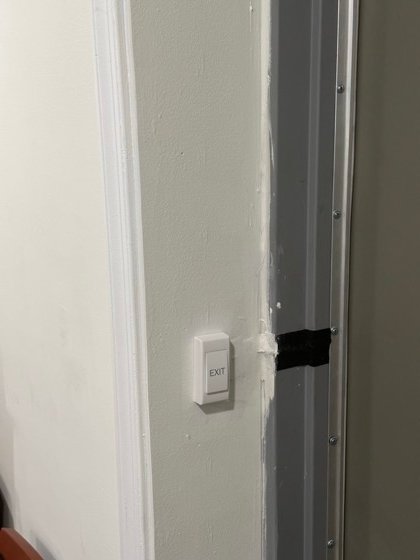 Request-to-exit button inside the door &mdash; free egress on the way out, locked from the outside.