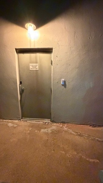 Replacement readers set into a brick wall at a Wilmington financial office &mdash; the old openings widened so the new reader sits flush, tamper alert on.