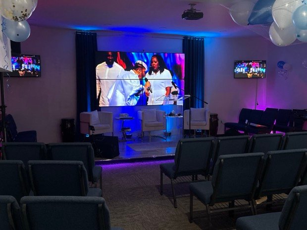 The finished wall in service &mdash; one image carried across all four panels, with the flanking displays repeating it to every seat.